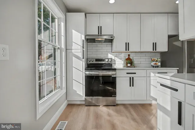 a kitchen with cabinets stainless steel appliances and a sink