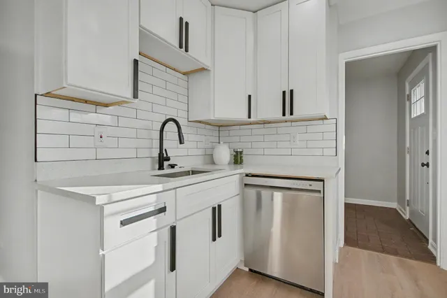 a kitchen with white cabinets and a sink