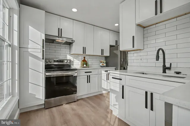 a kitchen with cabinets stainless steel appliances and sink