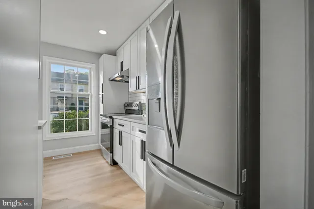 a kitchen with stainless steel appliances granite countertop a refrigerator and a sink