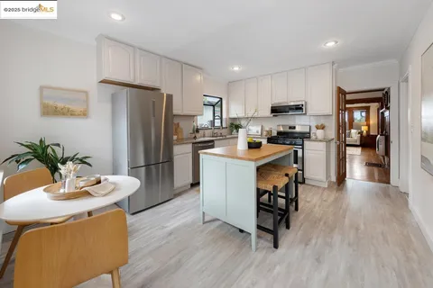 a kitchen with a refrigerator a stove top oven a sink dishwasher and white cabinets with wooden floor