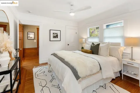 a spacious bedroom with a bed and a lamp on dresser