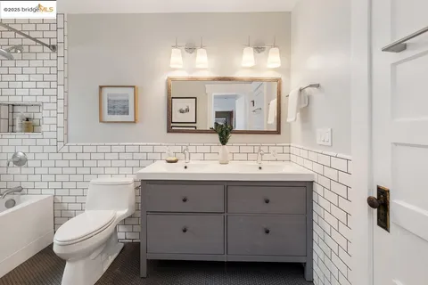 a bathroom with a double vanity sink mirror and toilet