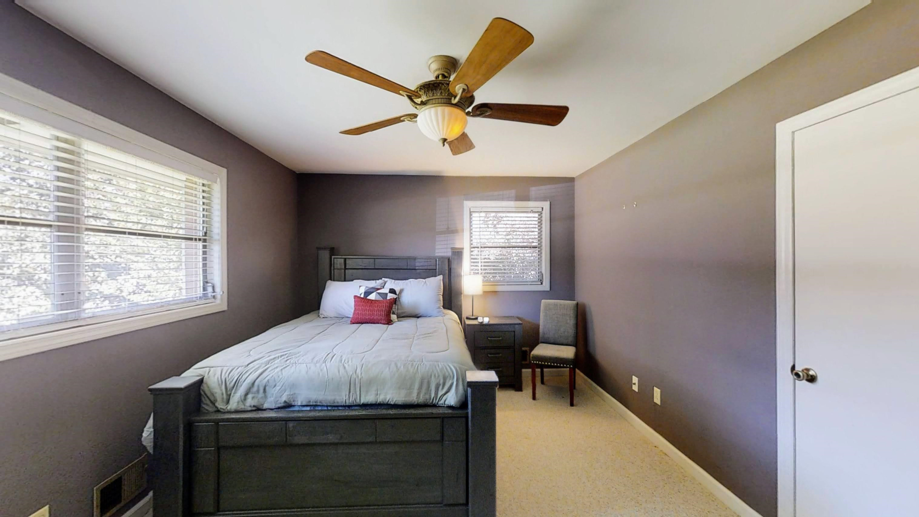 1115 Perry Road Zebulon, NC 27597 - Photo 14 of 37 a bedroom with a bed and a chandelier