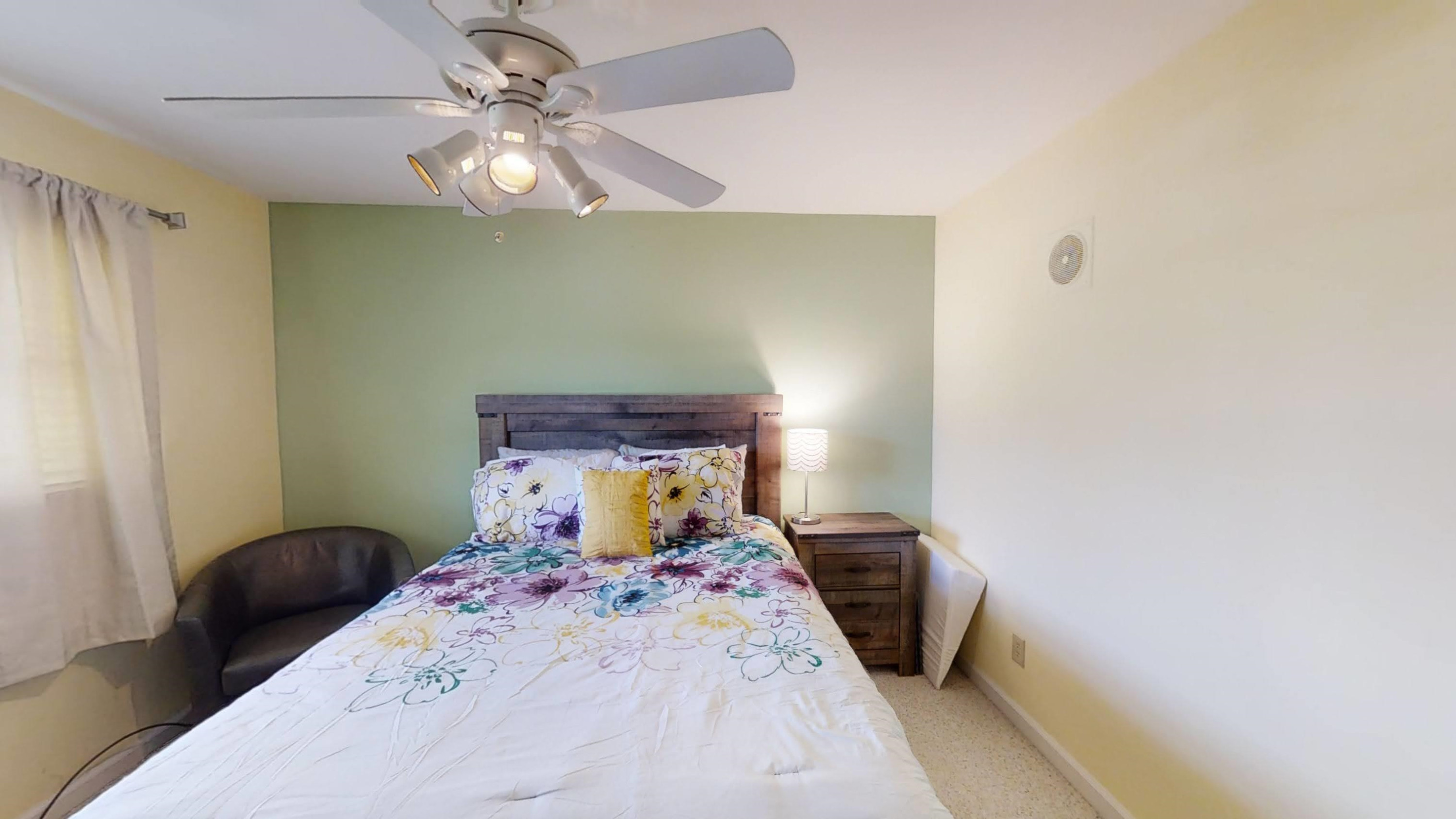 1115 Perry Road Zebulon, NC 27597 - Photo 16 of 37 a bed room with a bed and a chandelier