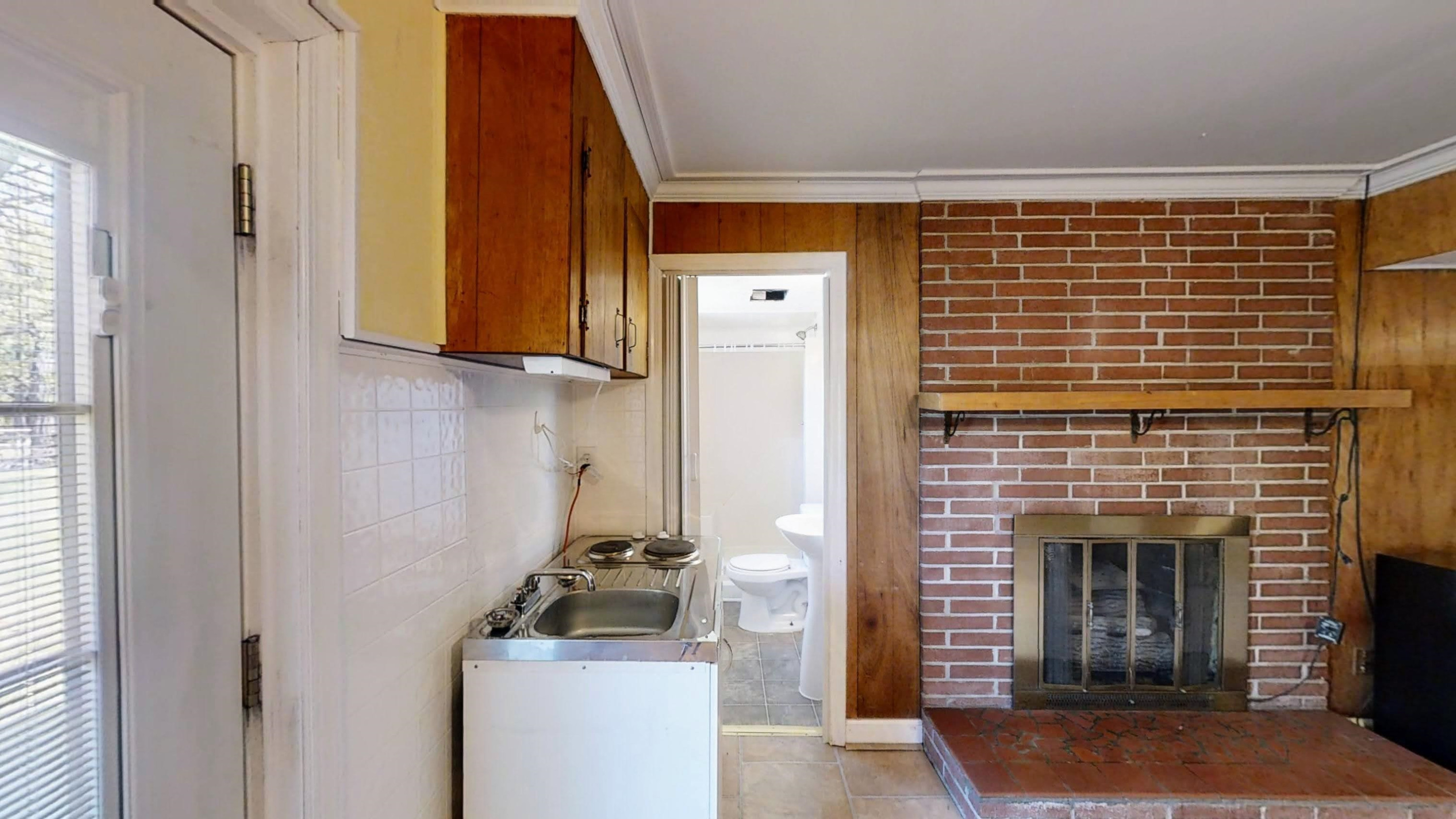 1115 Perry Road Zebulon, NC 27597 - Photo 26 of 37 a room with a fireplace and a window