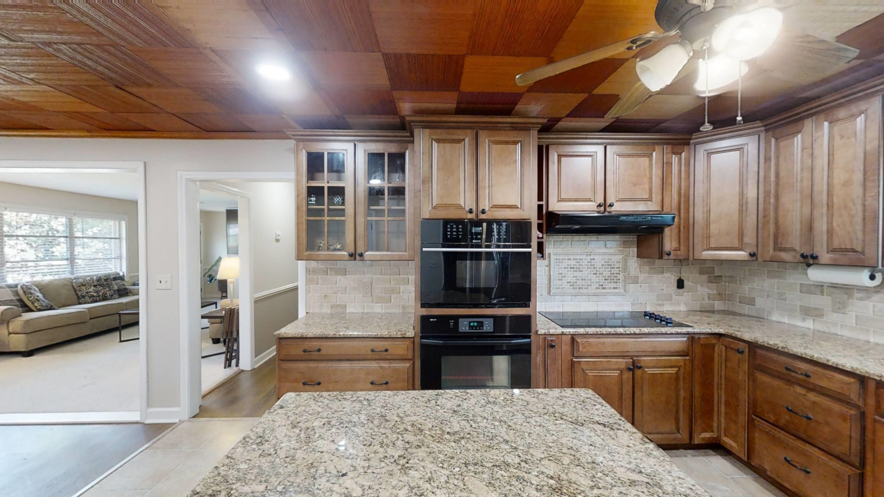 1115 Perry Road Zebulon, NC 27597 - Photo 7 of 37 a kitchen with kitchen island granite countertop a sink cabinets and stainless steel appliances