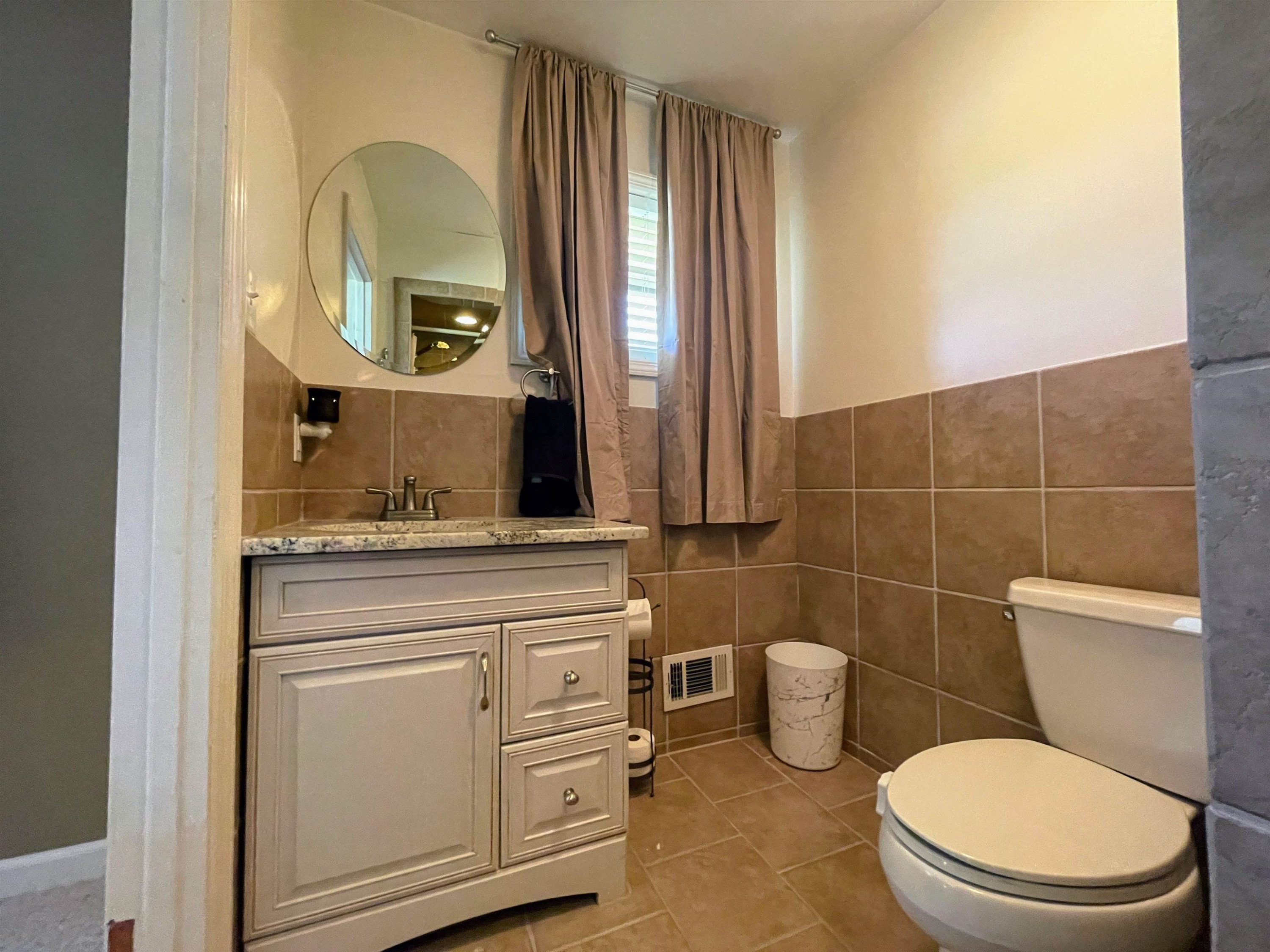 1115 Perry Road Zebulon, NC 27597 - Photo 10 of 37 a bathroom with a toilet a sink and mirror