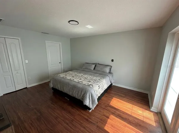 a bedroom with a bed and wooden floor