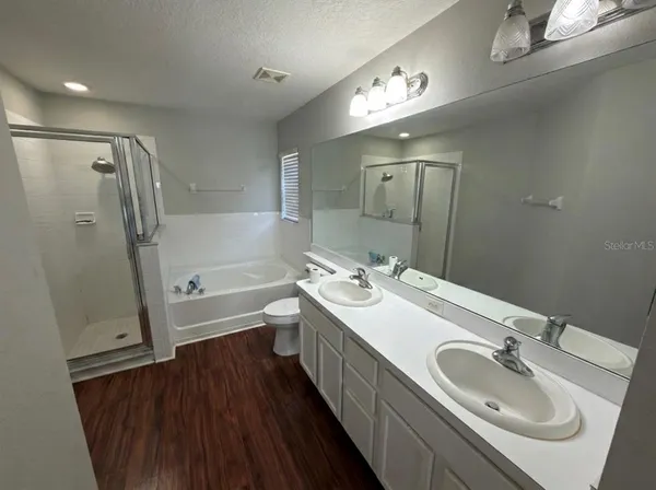 a bathroom with a double vanity sink a mirror and a bathtub