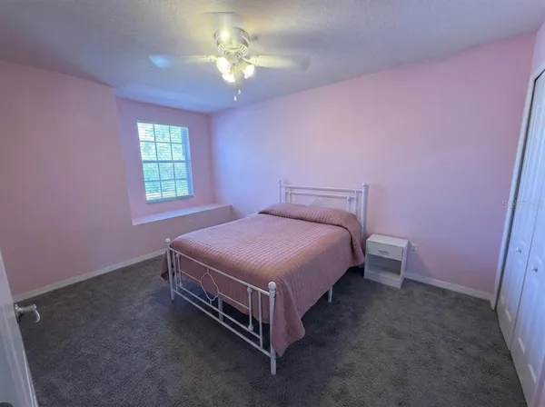 a spacious bedroom with a bed and a chandelier