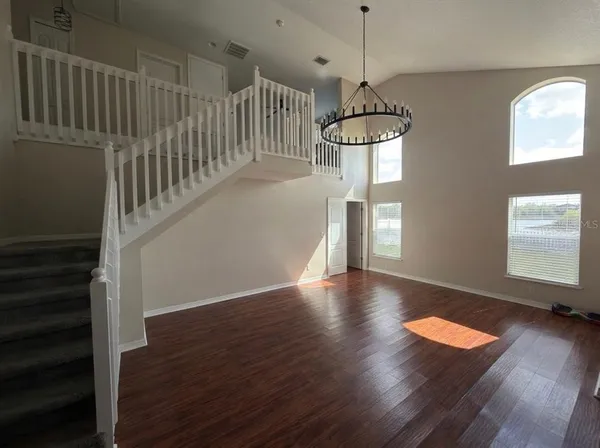a view of a room with wooden floor water view and windows