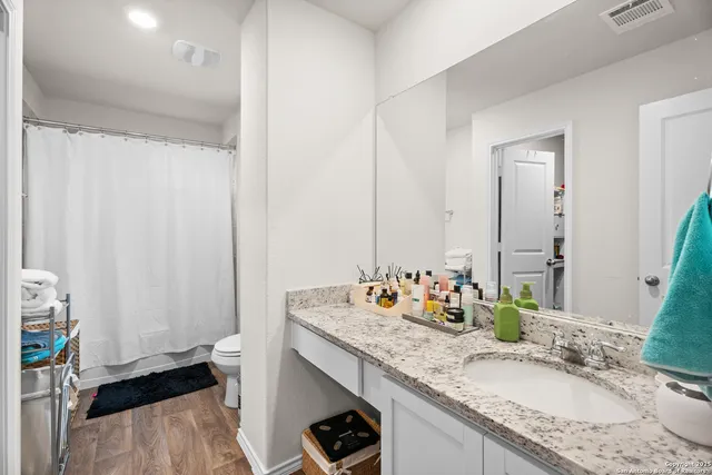 a bathroom with a granite countertop sink and a mirror