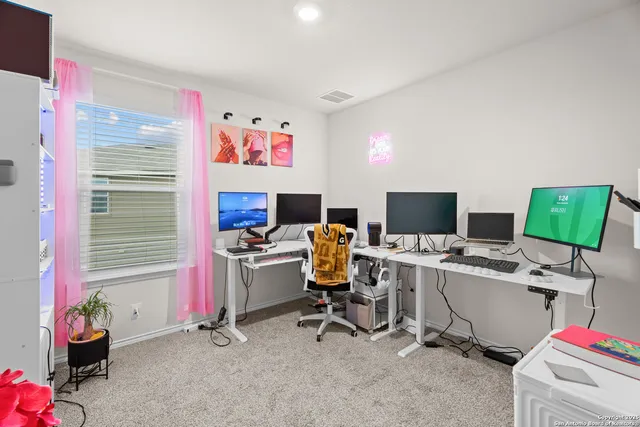 a view of a workspace with furniture and a window