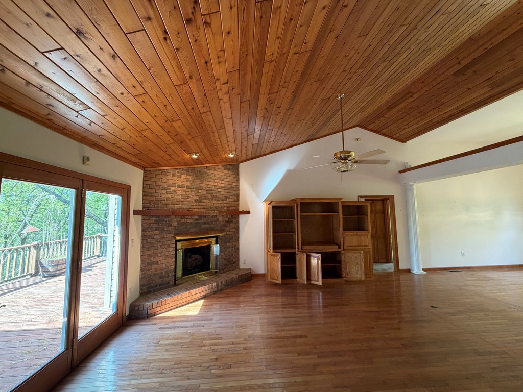78 Timber Ridge Lane Hayesville, NC 28904 - Photo 8 of 43 an empty room with wooden floor fireplace and windows