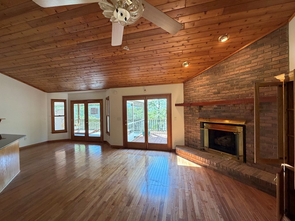 78 Timber Ridge Lane Hayesville, NC 28904 - Photo 10 of 43 an empty room with wooden floor fireplace and windows