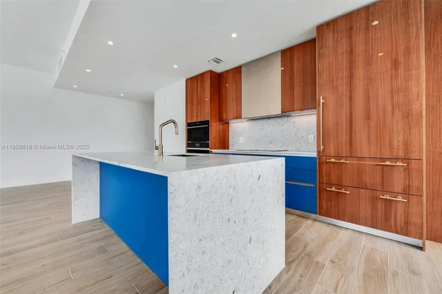 a kitchen with stainless steel appliances granite countertop a refrigerator a sink and a stove