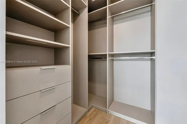 a view of walk in closet with empty racks