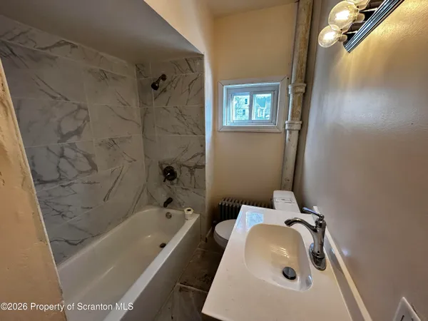 a bathroom with a tub sink and mirror
