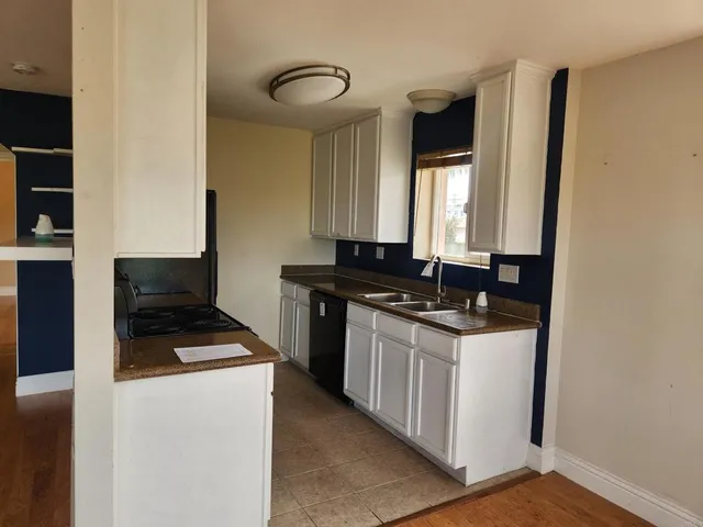a kitchen with granite countertop a stove and a sink