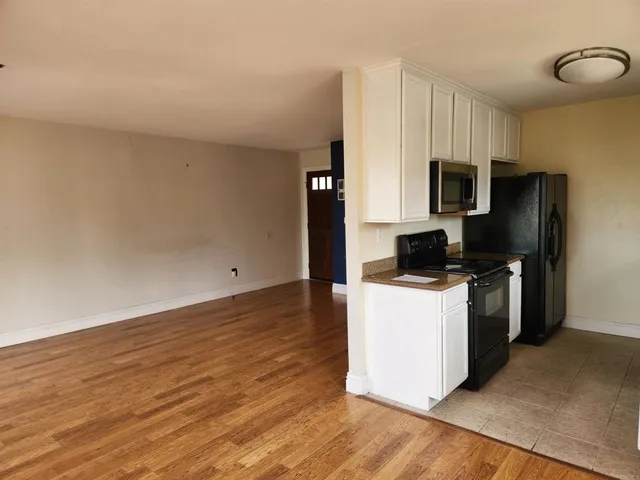 a kitchen with a refrigerator and a stove top oven