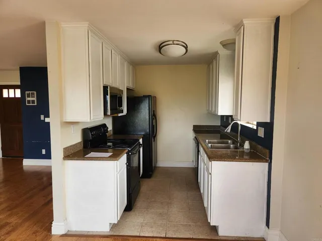 a kitchen with stainless steel appliances granite countertop a sink stove refrigerator and cabinets
