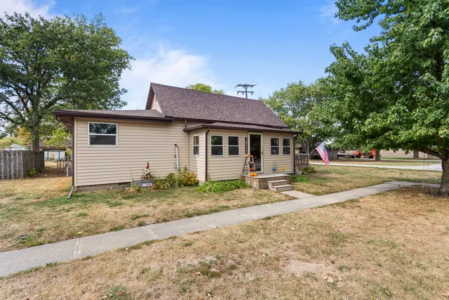 a view of a house with a yard and large tree