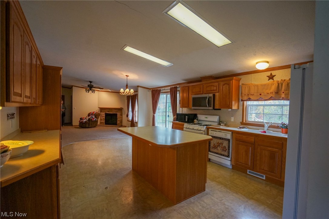 37632 Sheepskin Ridge Road Lower Salem, OH 45745 - Photo 2 of 30 Kitchen featuring ceiling fan with notable chandelier, a center island, pendant lighting, and light tile floors