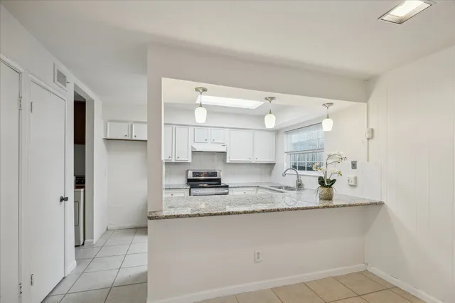 a kitchen with stainless steel appliances granite countertop a refrigerator and a stove