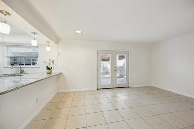 a large white kitchen with a sink and cabinets