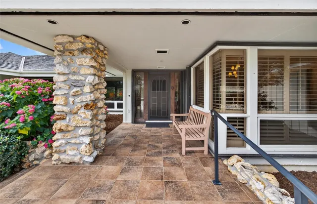 a living room with a large window and potted plants