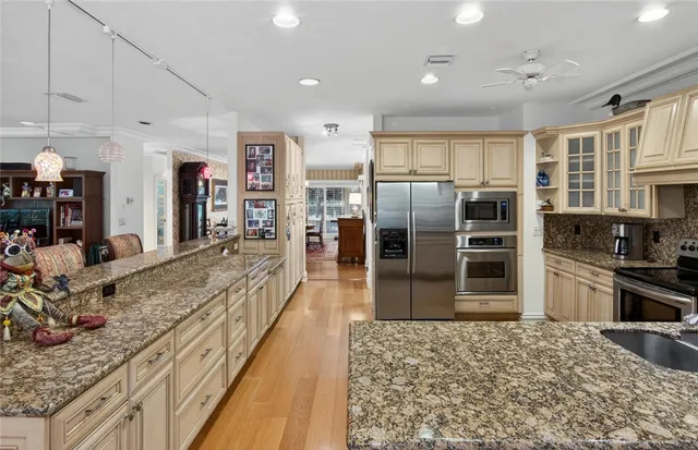 a large kitchen with kitchen island granite countertop a large counter top stainless steel appliances and cabinets