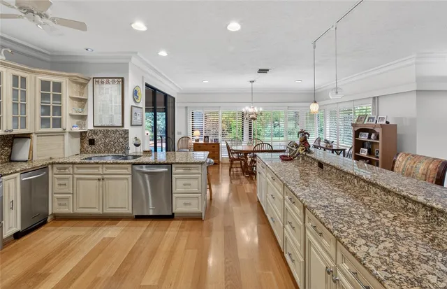 a large kitchen with kitchen island a large counter space a sink stainless steel appliances and cabinets