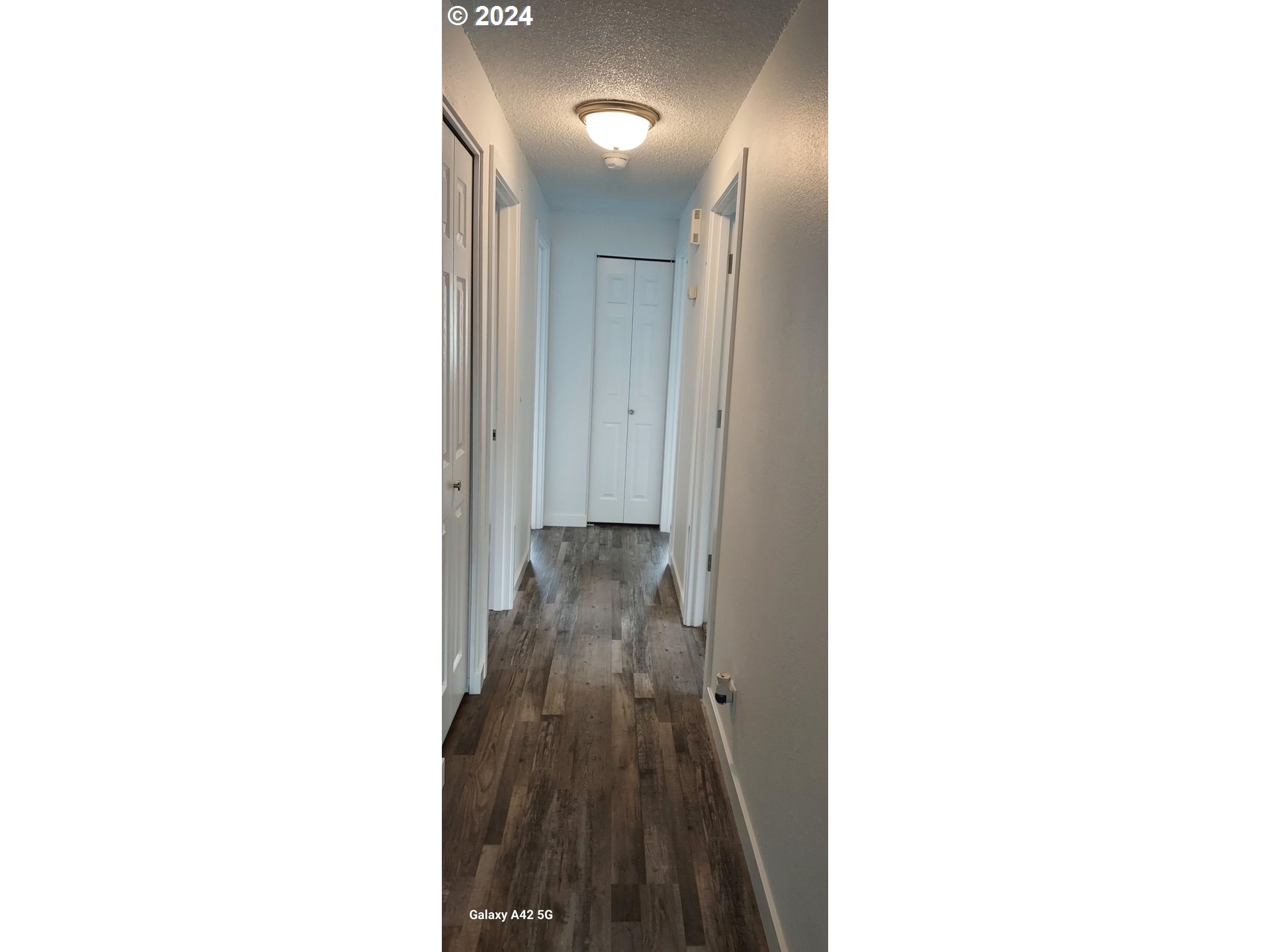 2573 L Street Springfield, OR 97477 - Photo 17 of 22 a view of a hallway with wooden floor and a large mirror