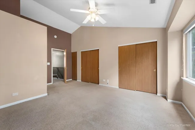 an empty room with closet and a ceiling fan