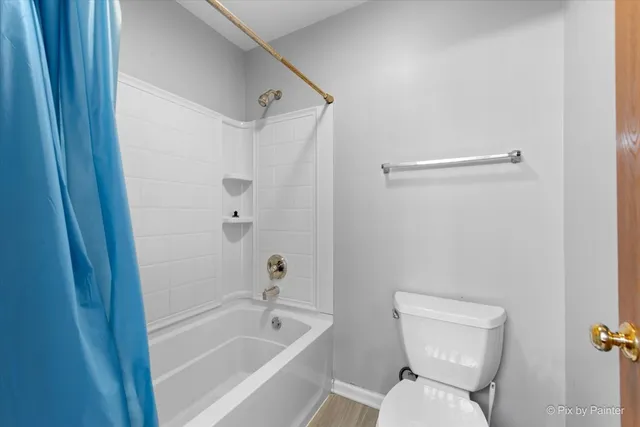 a white toilet sitting next to a bath tub