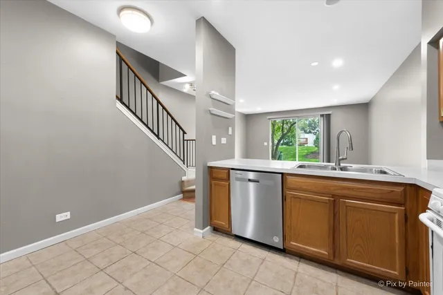 a view of a kitchen with sink electronic appliances and window