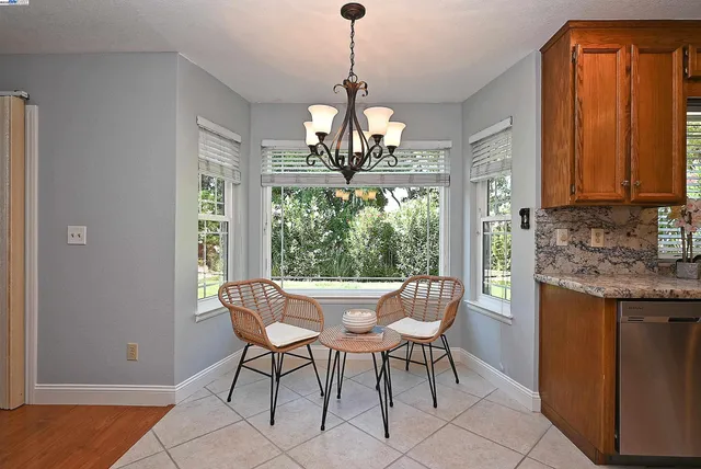 a dining room with furniture a chandelier and wooden floor