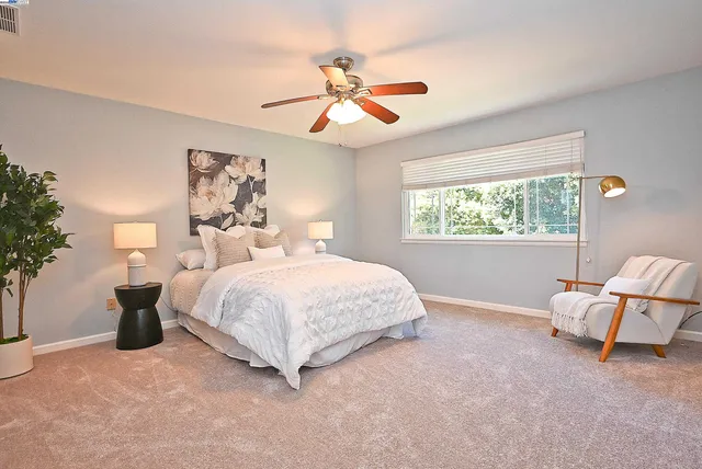 a bedroom with a large bed and a chandelier