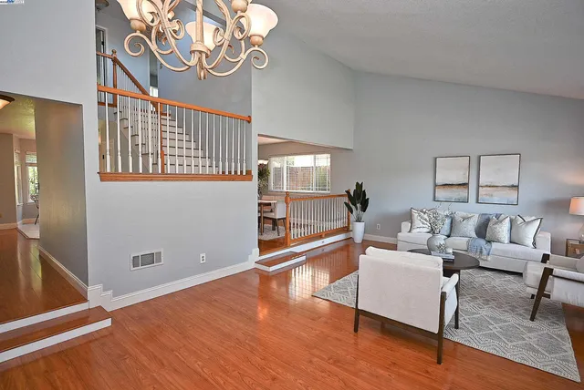 a living room with furniture large window and wooden floor