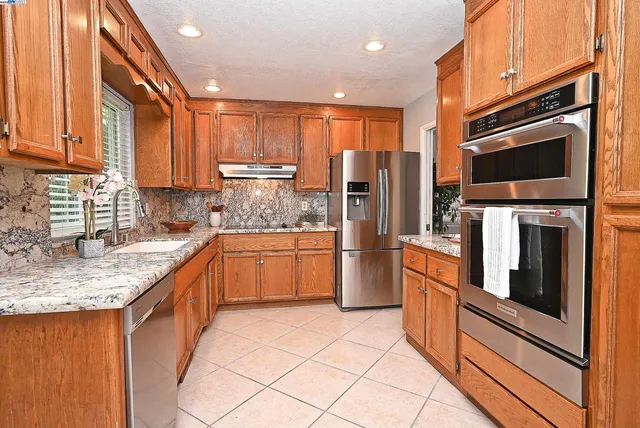 a kitchen with stainless steel appliances granite countertop a refrigerator sink and cabinets