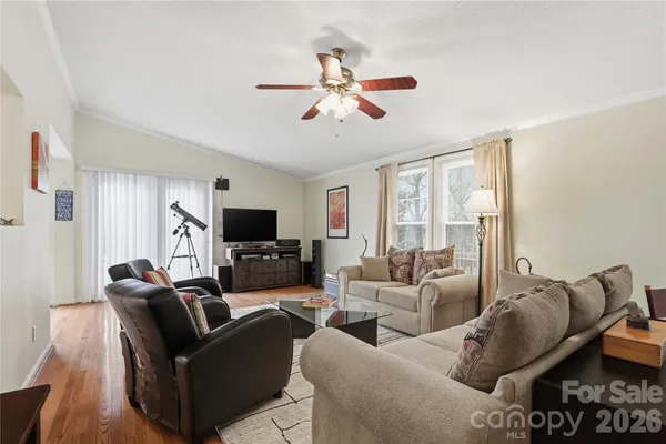 a living room with furniture a ceiling fan and a flat screen tv