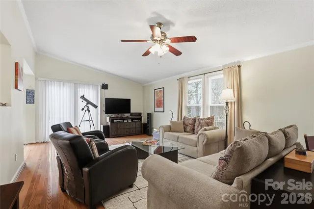 a living room with furniture a ceiling fan and a flat screen tv