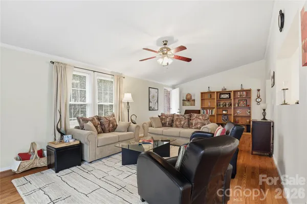 a living room with furniture ceiling fan and a window