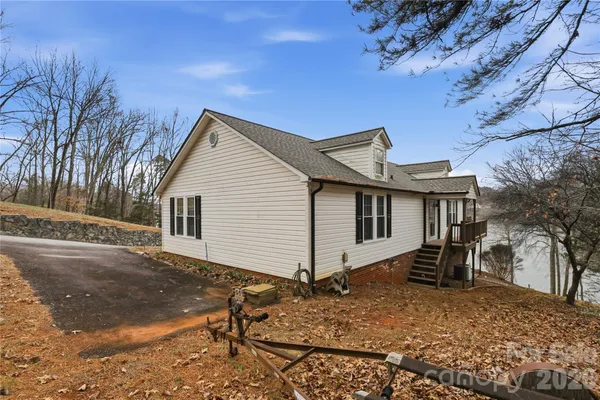 a front view of a house with garden and trees