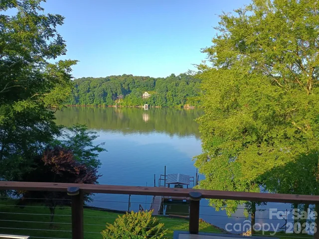 a backyard of a house with large trees and covered with snow