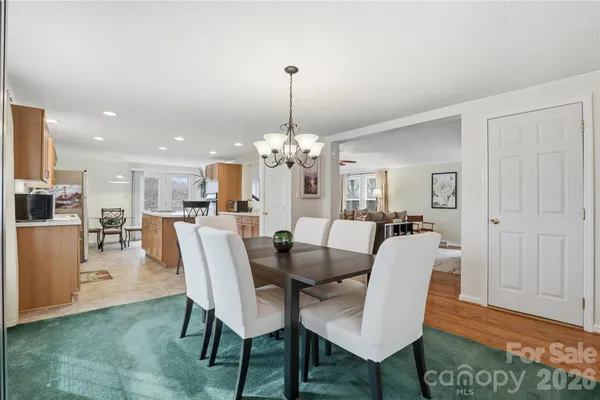 a dining room with furniture a chandelier and wooden floor