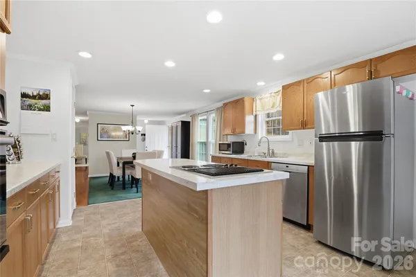 a kitchen with stainless steel appliances granite countertop a refrigerator a stove a sink and a refrigerator