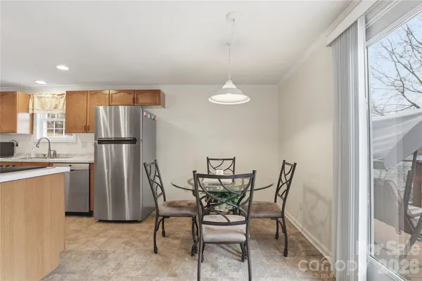 a view of a dining room with furniture and a refrigerator
