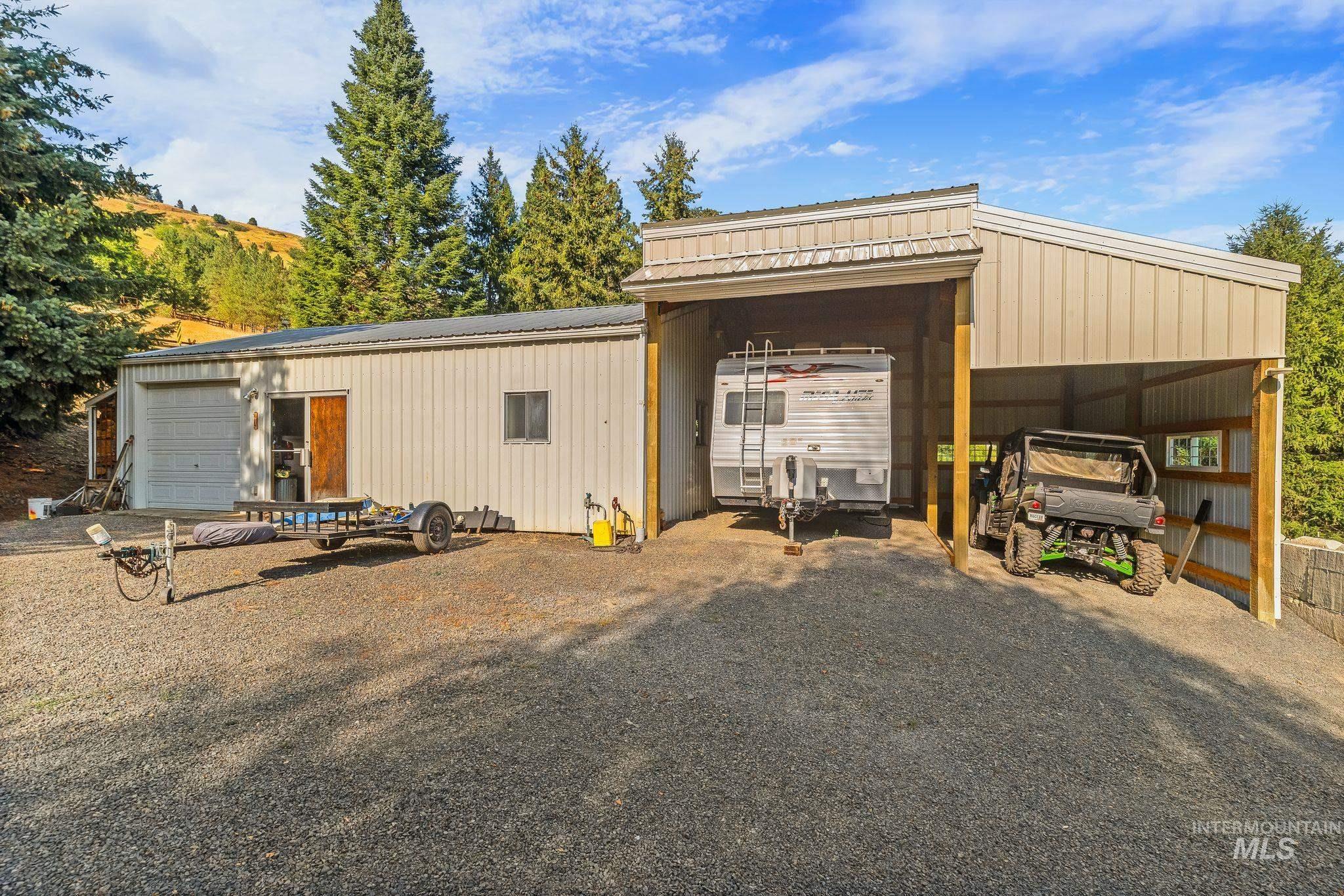 1091 Cedar Ridge Road Kendrick, ID 83537 - Photo 17 of 48 Metal outbuilding featuring a single garage door, a sliding glass door entry, and a window